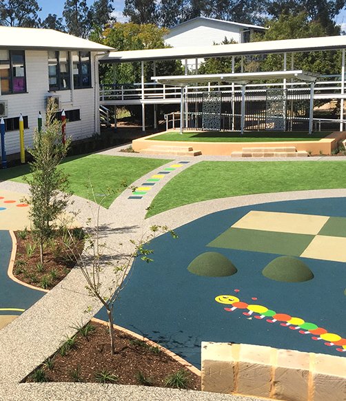 A vibrant, active youth zone outdoor play area with colorful equipment